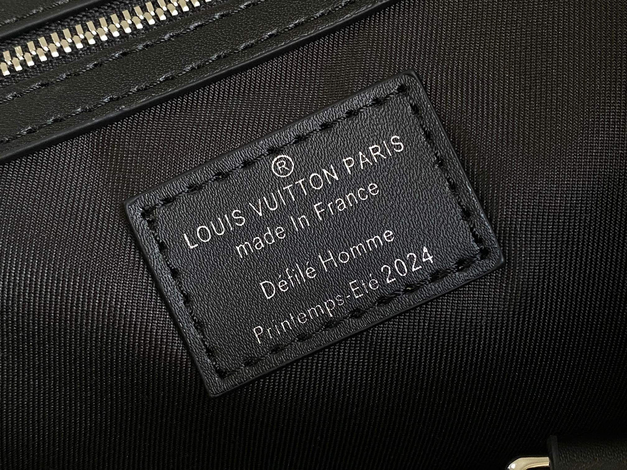 Louis Vuitton bag leather interior label, dark fabric with text