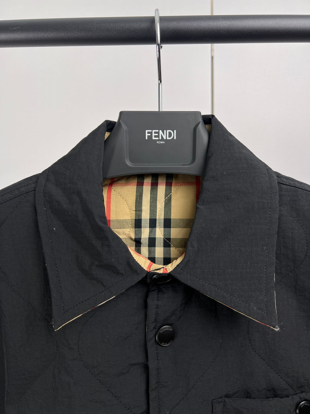 Quilted jacket with stand collar, dark outer and plaid lining at neckline