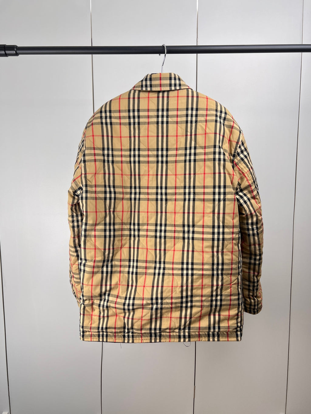 Plaid puffer jacket back view with black collar and buttoned long sleeves