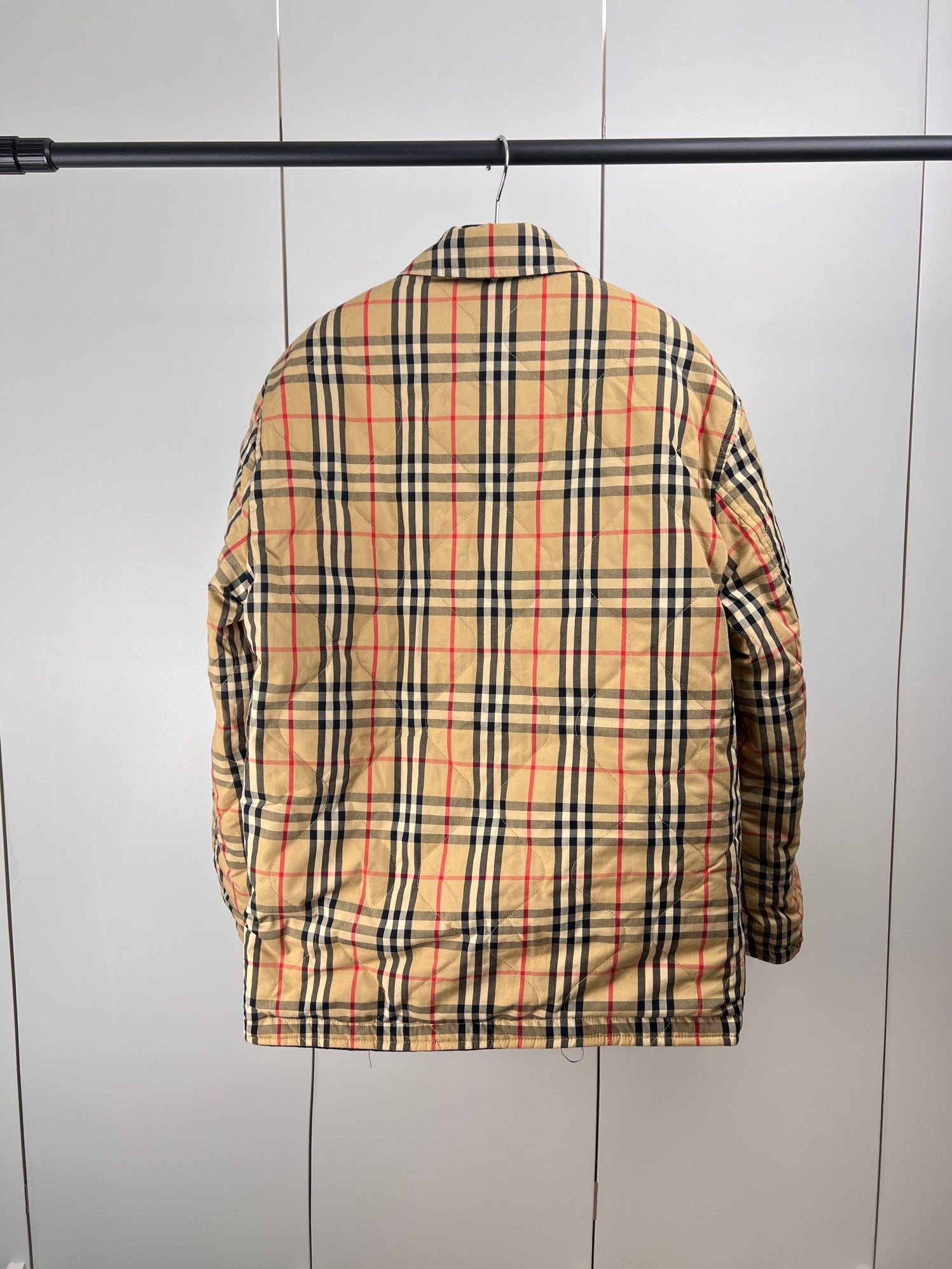Plaid puffer jacket back view with black collar and buttoned long sleeves