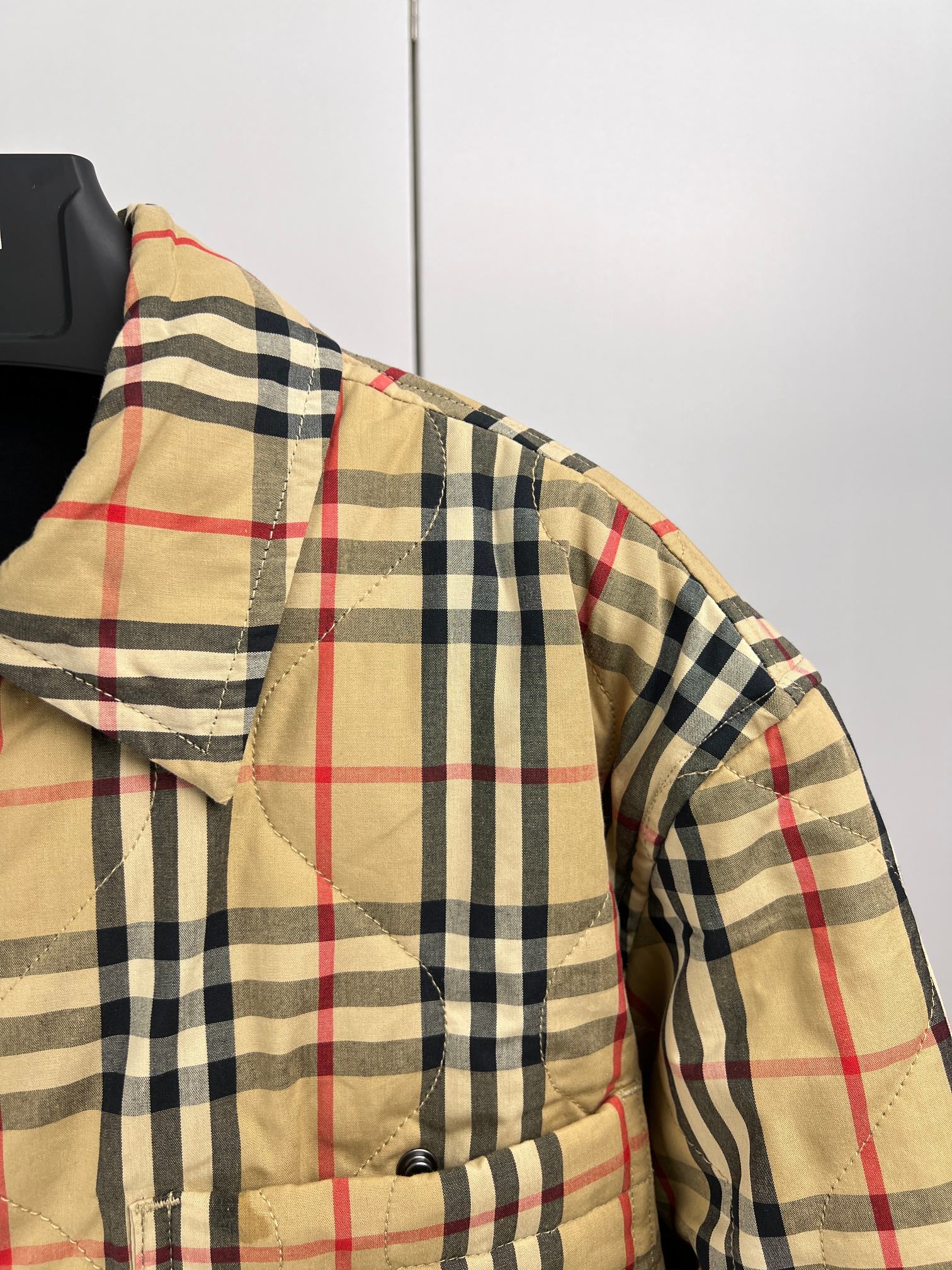 Plaid puffer jacket shoulder and sleeve with quilted panels and button placket