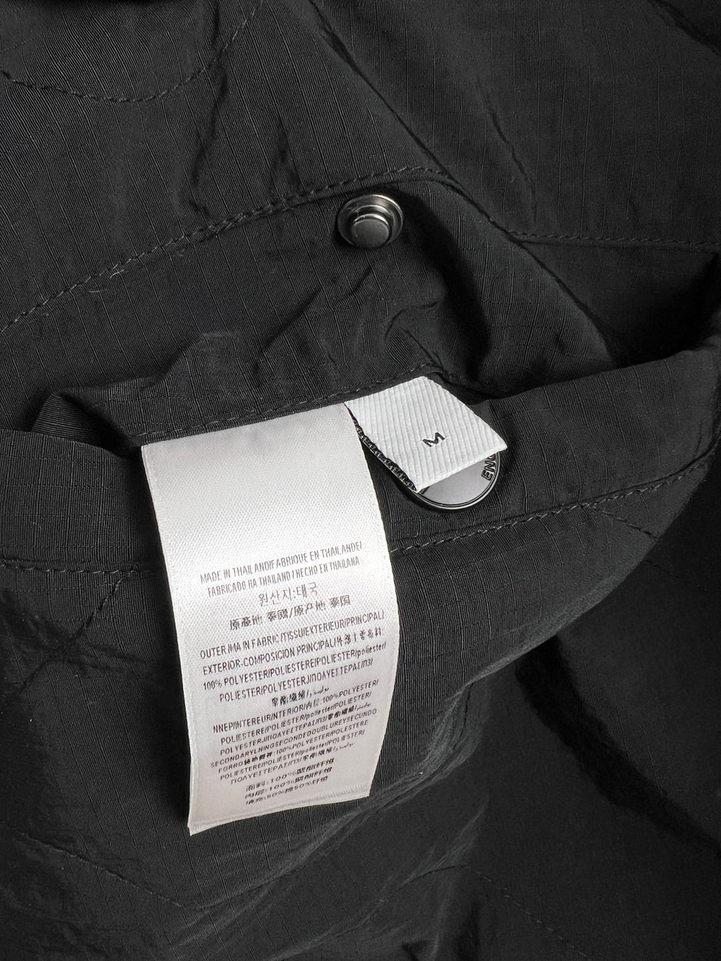 Black long jacket with quilted fabric and interior label tag