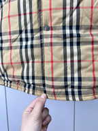 Plaid puffer jacket hem with button closure and quilted stitching