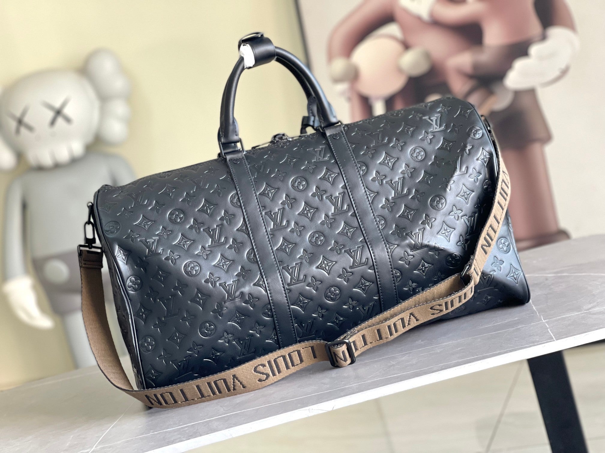 Men’s Louis Vuitton monogram duffel bag with structured end, dual top handles, and shoulder strap