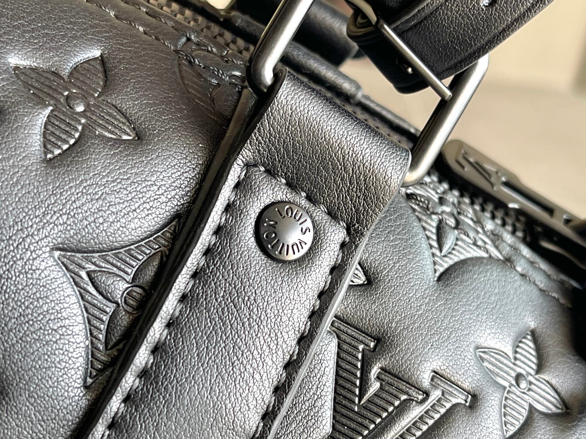 Louis Vuitton monogram leather close-up of strap stitching and metal buckle
