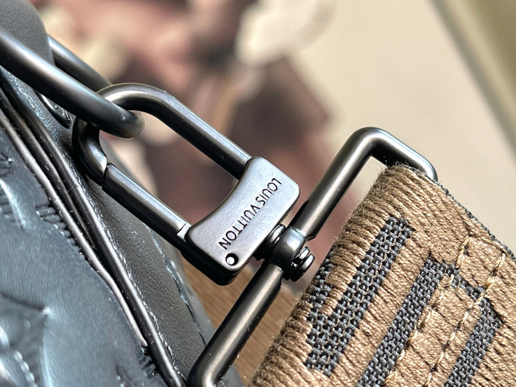 Louis Vuitton monogram duffel close-up of metal rings and beige strap label