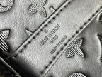 Louis Vuitton duffel bag close-up of monogram embossing and stitched seam on leather panel
