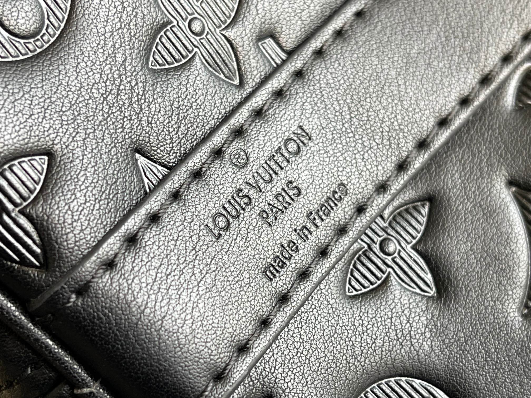 Louis Vuitton duffel bag close-up of monogram embossing and stitched seam on leather panel