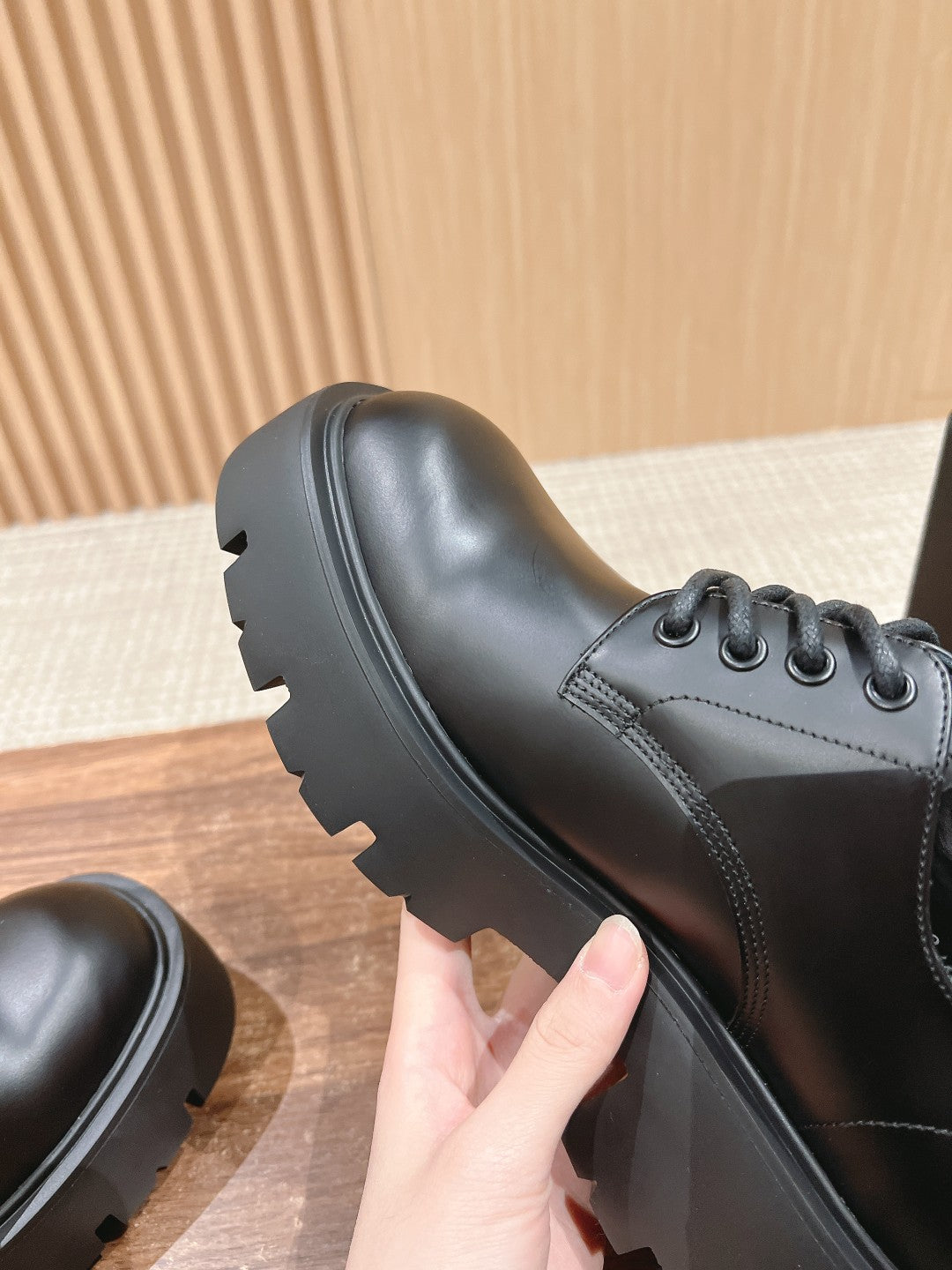 Black leather lace-up shoe side view with sculpted tread sole