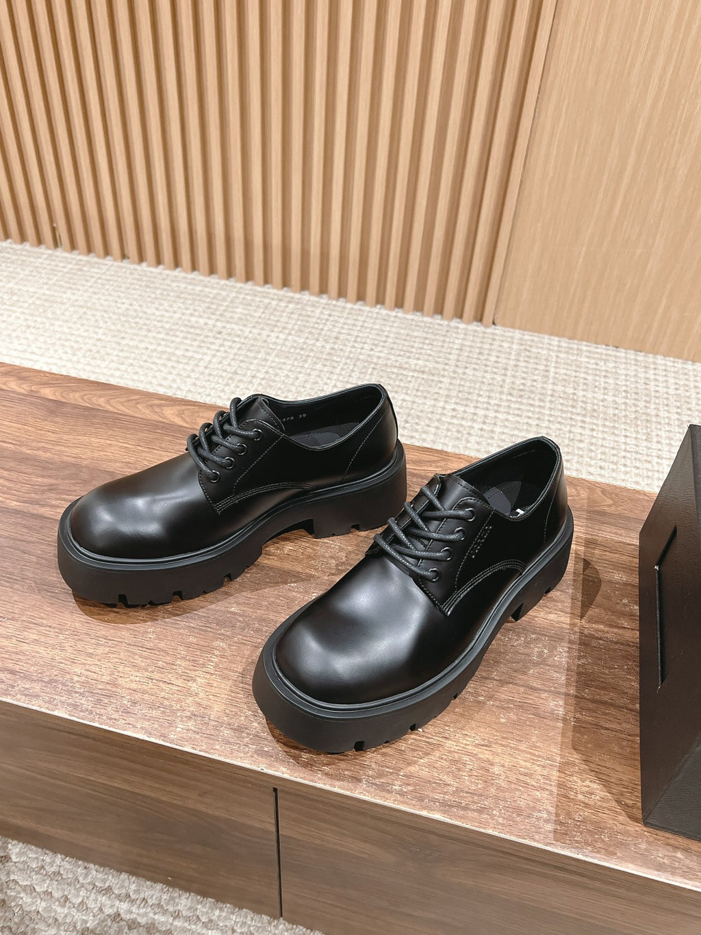 Black lace-up leather shoes with stitched panels and chunky rubber sole