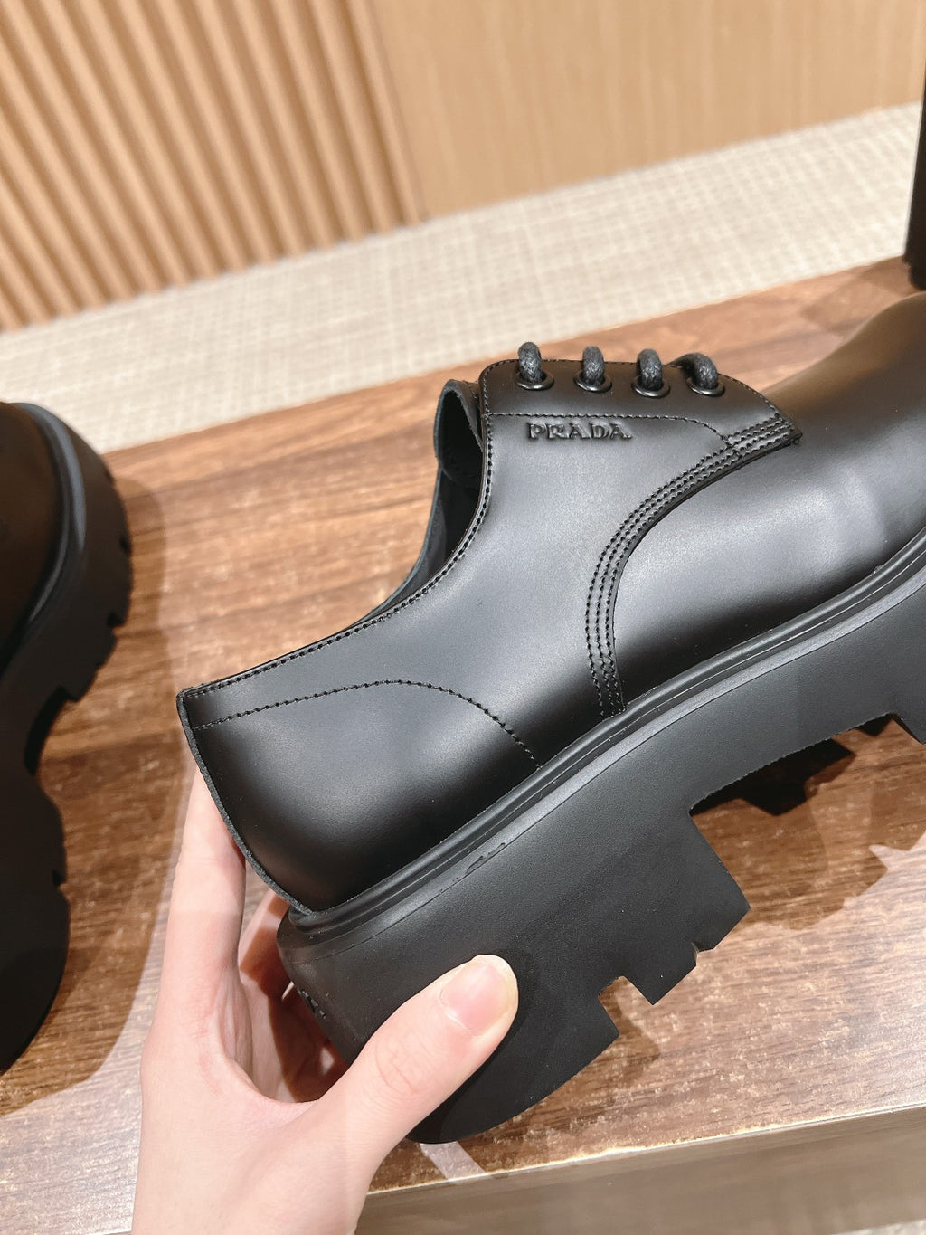 Black leather lace-up shoe with logo detail and rugged sole