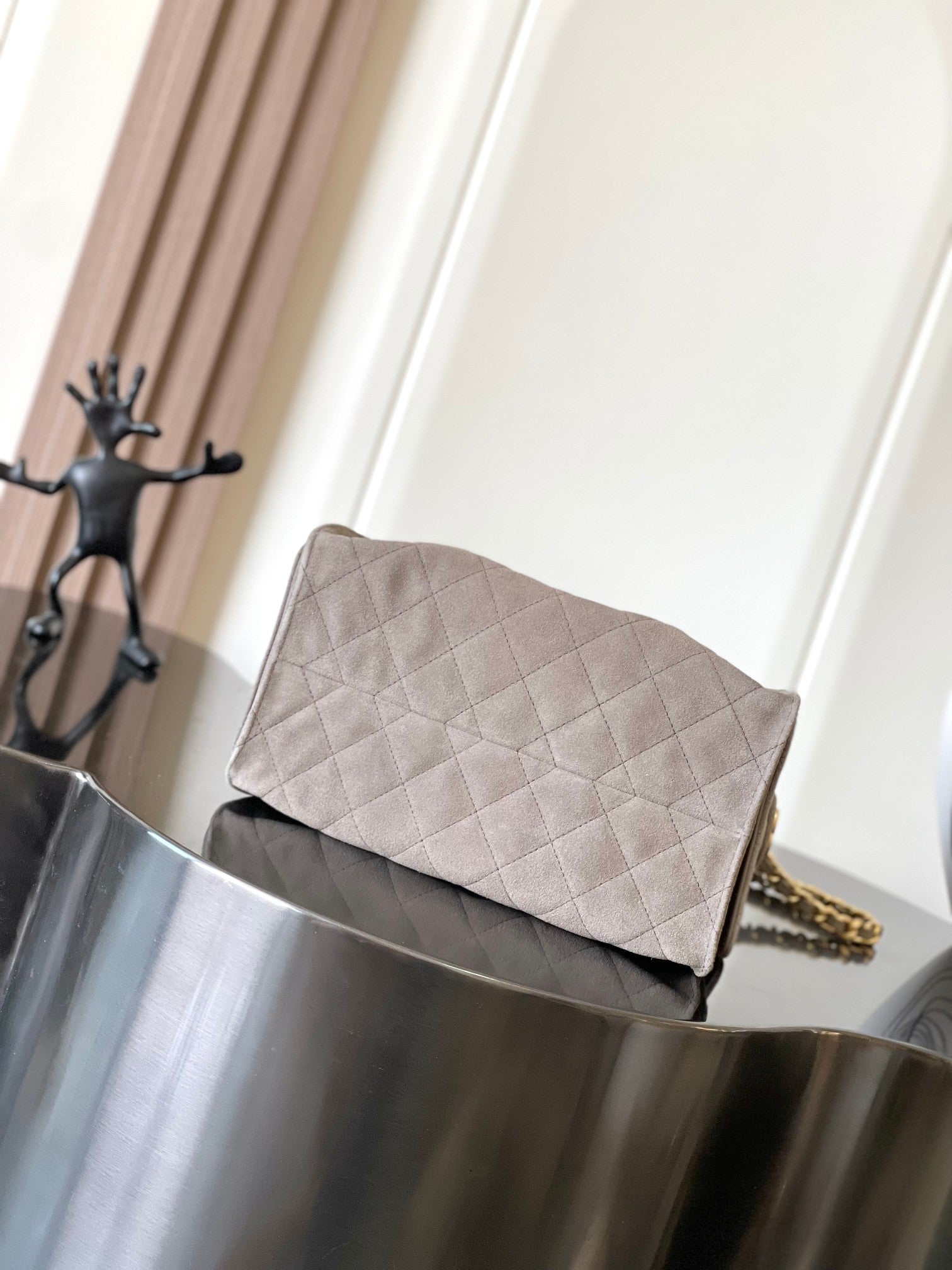 Light gray quilted shoulder bag with flap top and gold-tone chain detail