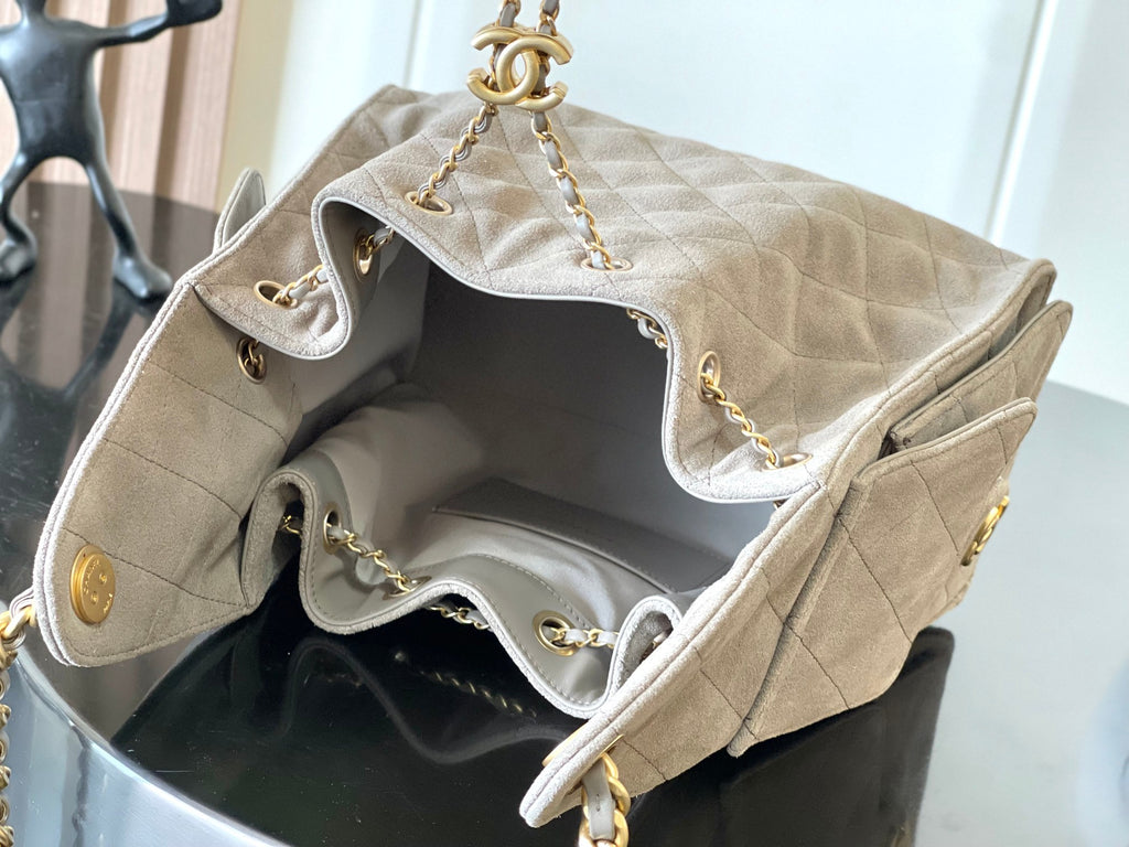 Open light gray quilted bag interior with gold-tone chain straps and hardware