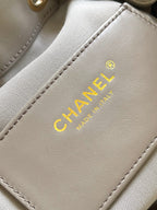 Light gray leather bag label reading Chanel and Made in France in gold text
