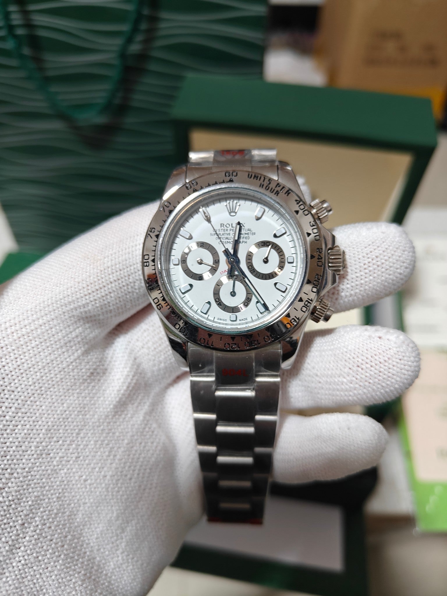 Rolex watch with silver dial and metal link bracelet, stainless steel chronograph.