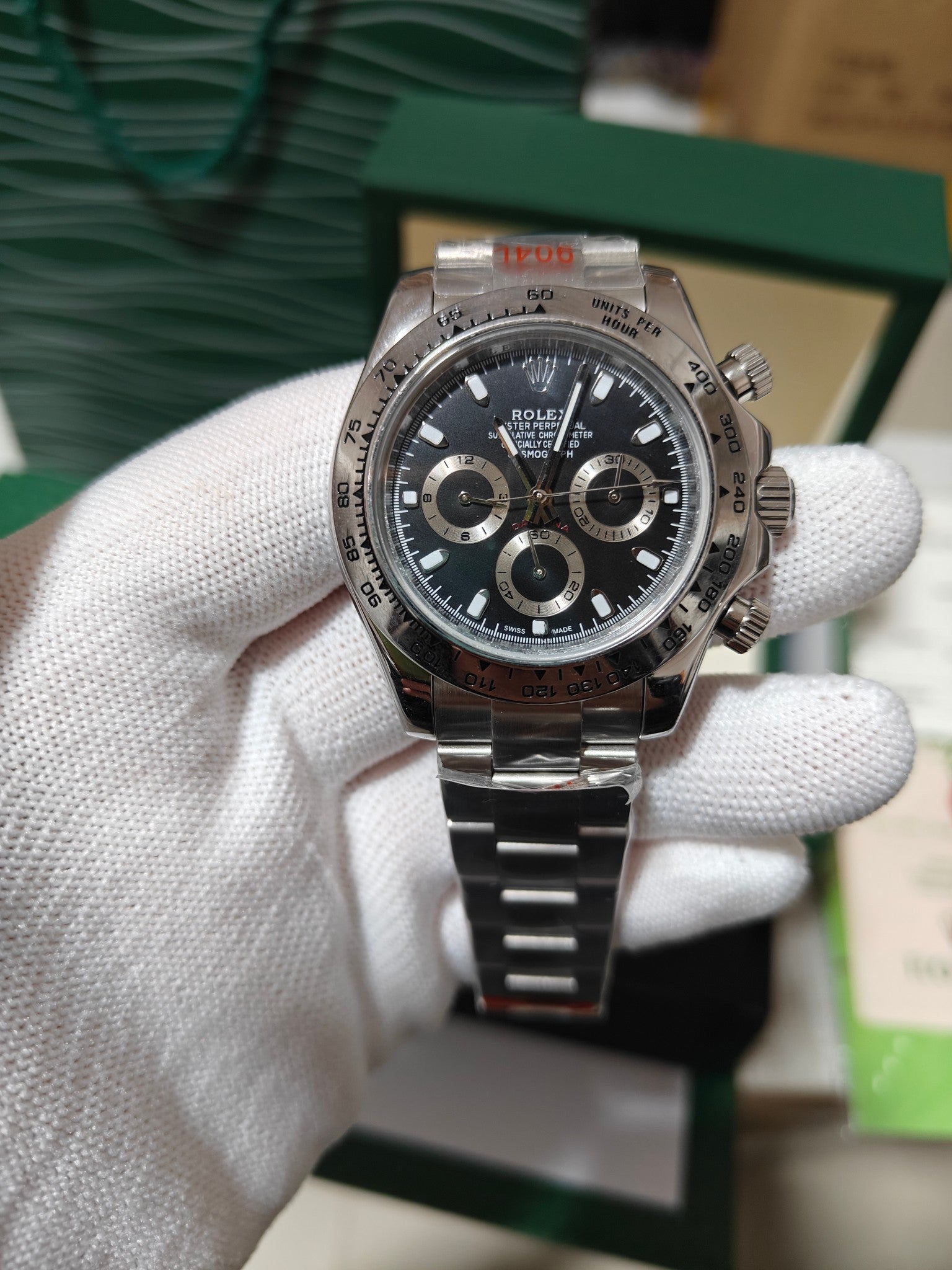 Rolex watch with dark dial and metal link bracelet, stainless steel case.