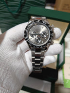 Rolex watch with gray dial, three chronograph subdials, and stainless steel bracelet