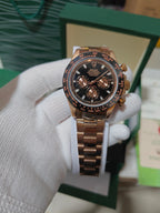 Rolex watch with rose-gold tone case, black dial, and rose-gold metal link bracelet