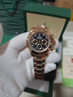 Rolex watch with rose-gold tone case, black dial, and metal link bracelet strap