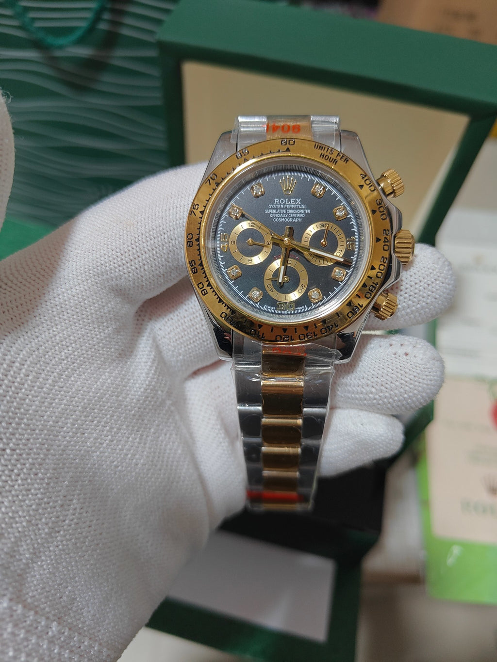 Rolex watch with gold-tone bezel, deep blue dial, three subdials and crown at 3