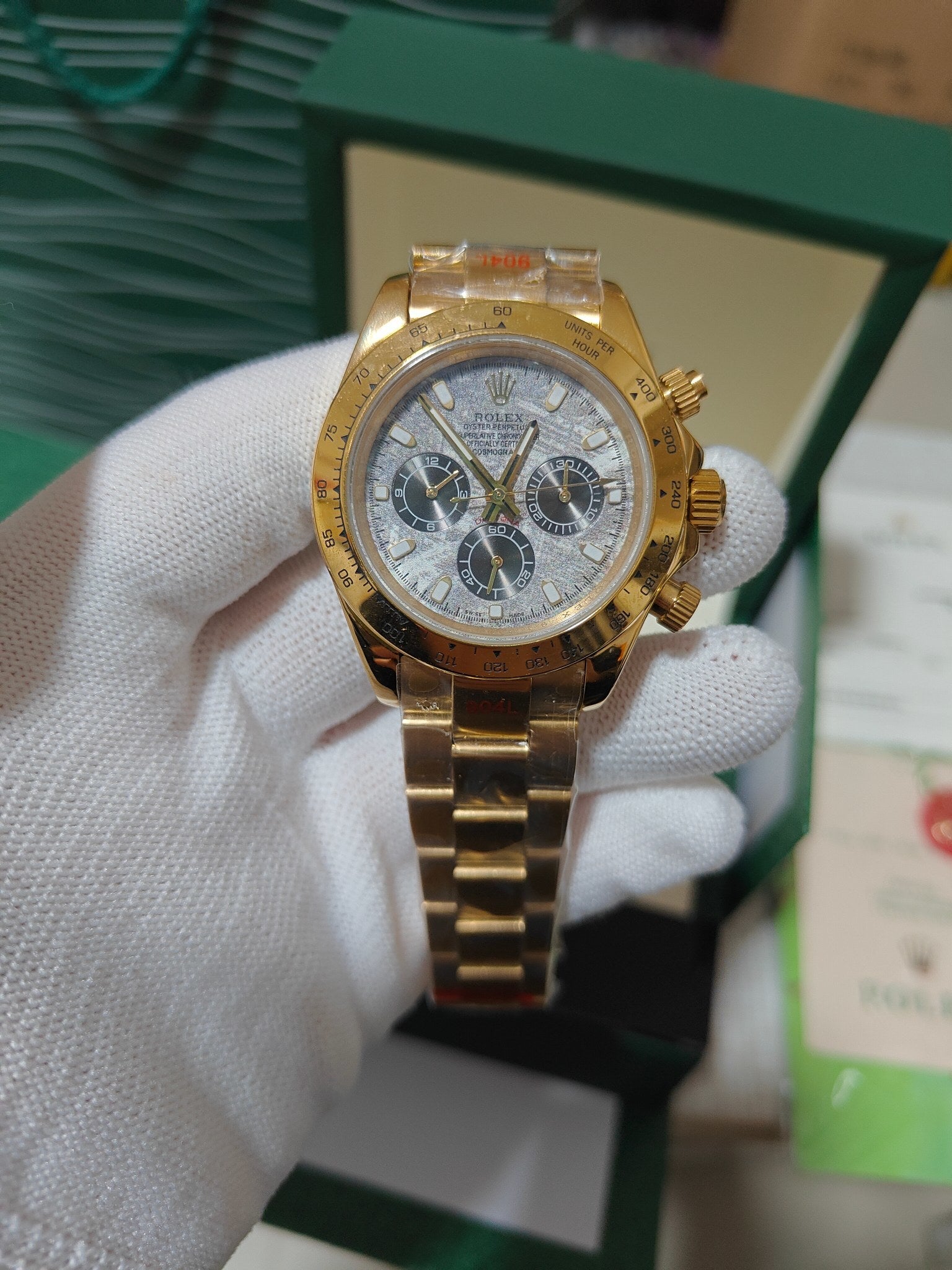Rolex watch with gold-tone bezel, light blue dial, three subdials and crown at 3