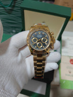 Rolex watch with gold-tone bezel, blue dial, three subdials and crown at 3