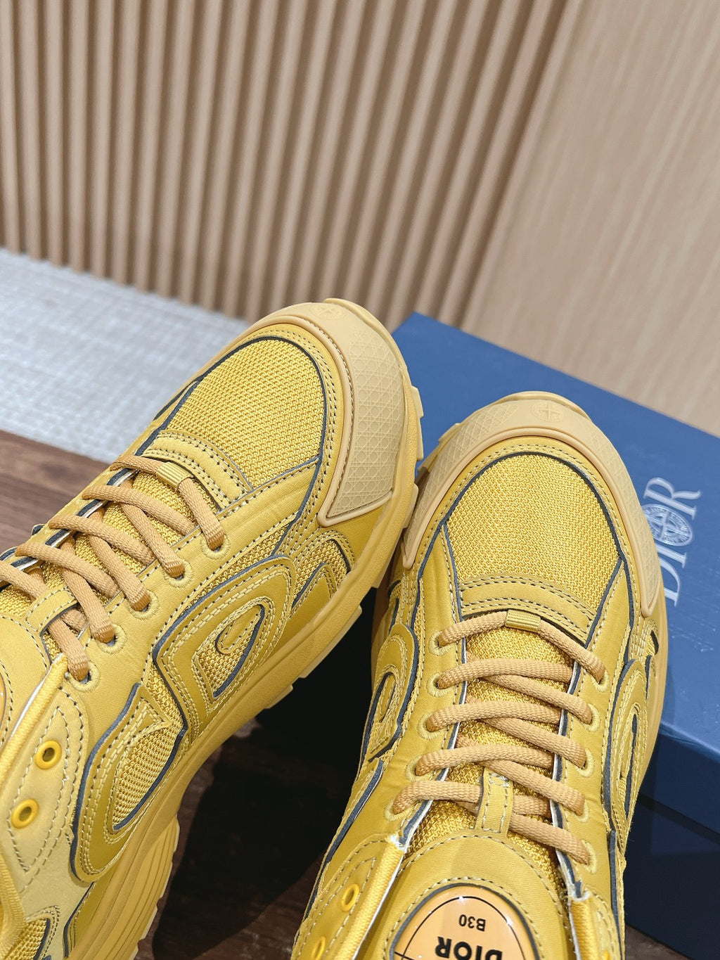 Close-up of yellow sneaker toe and side panel with woven texture