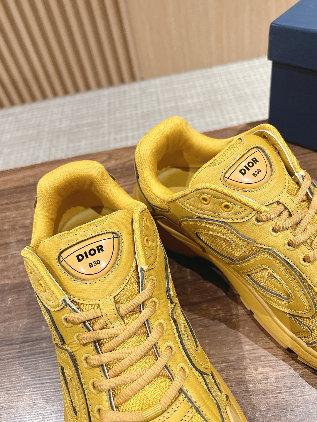 Pair of yellow Dior unisex lace-up sneakers with logo tongue labels