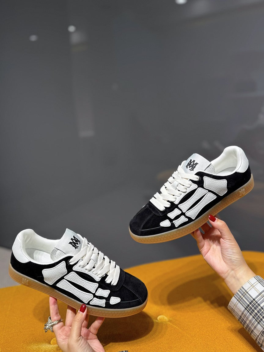 Black low-top sneaker with white geometric panels, lace-up front, gum sole