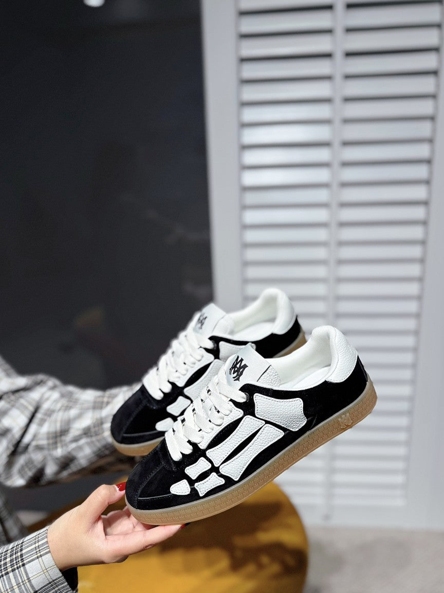 White-and-black low-top sneaker, lace-up with white panels, gum sole