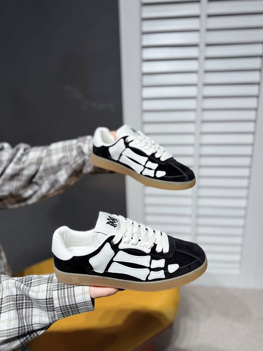 Black-and-white low-top sneaker on hand, lace-up with white pattern, gum sole