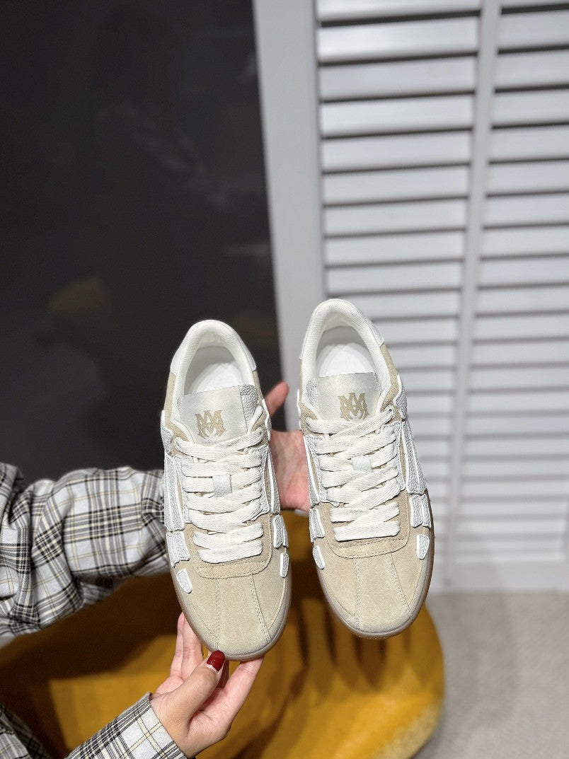 Amiri sneakers pair in cream with gray logo, lace-up design, front view
