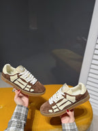 Pair of suede sneakers, brown and cream, with white laces and logo detailing