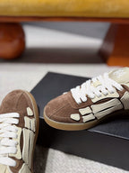 Close-up suede sneakers, brown and cream with white laces and logo detailing