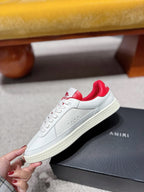 White low-top sneakers with red heel lining and red star side graphics on box