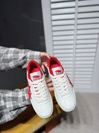 White low-top sneakers with red star logos and red heel lining, paired