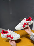 White low-top sneakers with red star graphics and red interior lining
