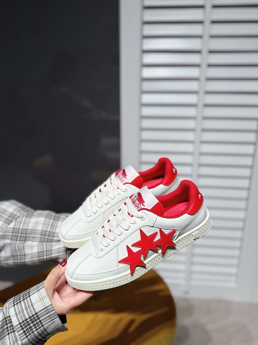 White low-top sneakers with red star detail and red collar lining, side view