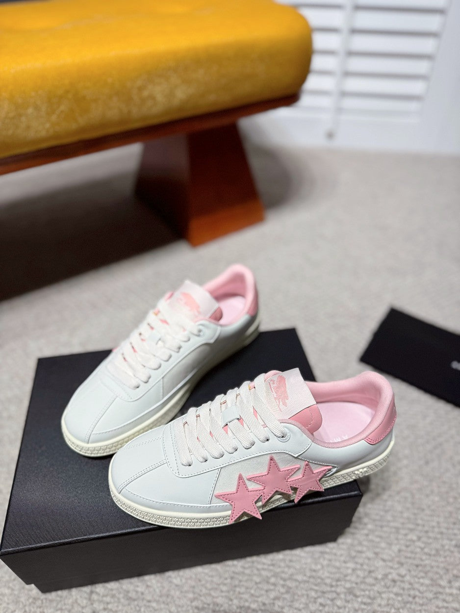 Pair of white low-top sneakers with pink star appliques on side panels