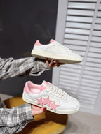 White low-top sneakers with pink star applique and pink interior lining