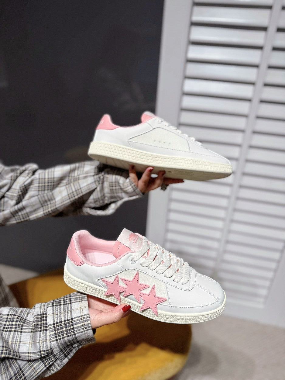 White low-top sneakers with pink star applique and pink interior lining