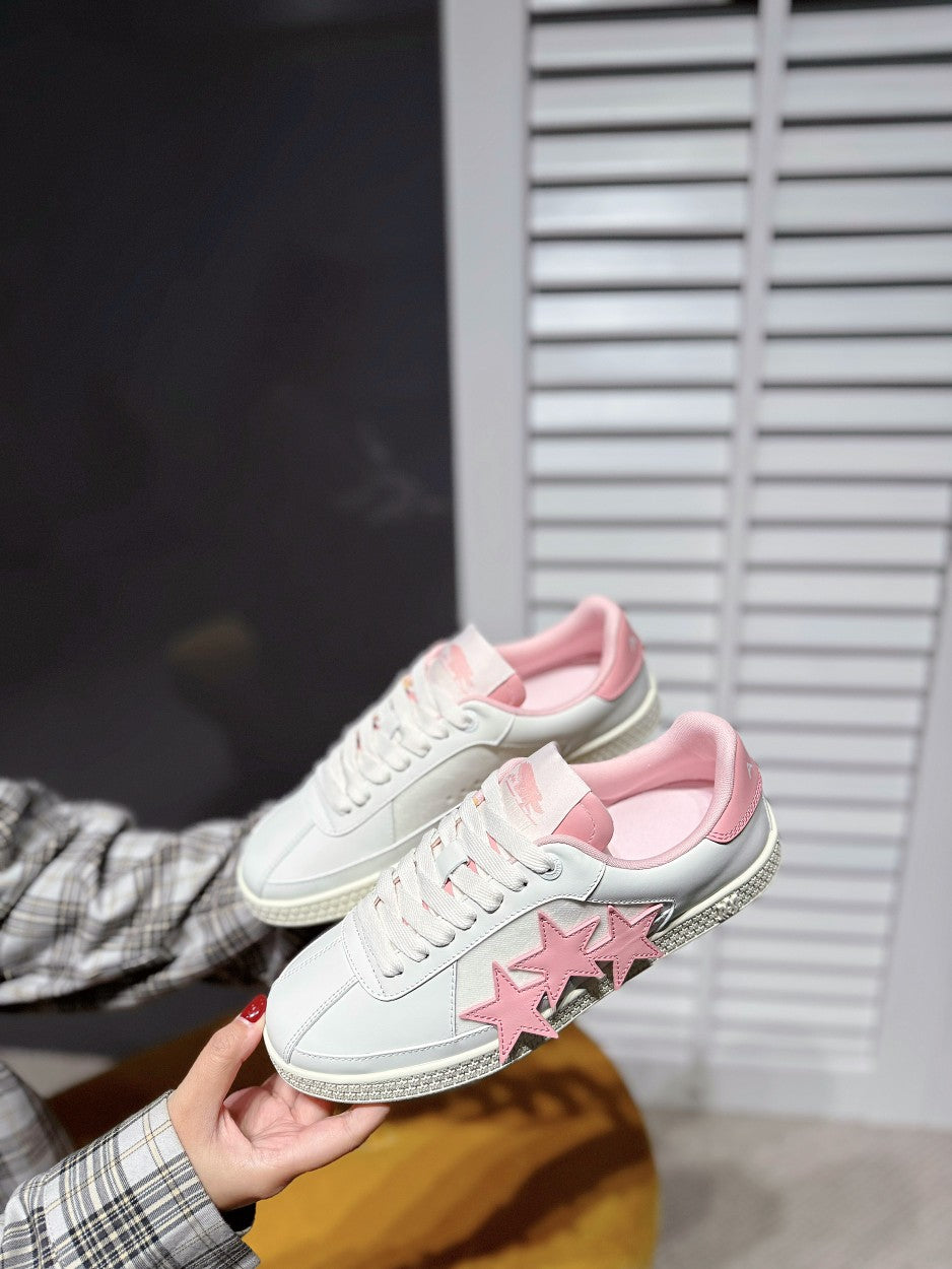 White low-top sneakers with pink star appliques and pink interior lining