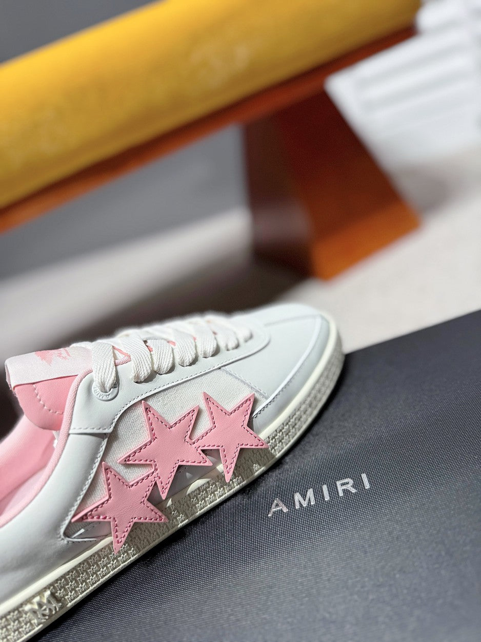 Side view of white sneaker with pink star appliques and glittery sole edge