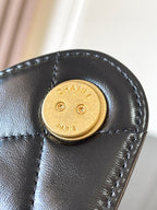 Chanel gold snap-button clasp on black leather flap bag
