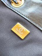 Chanel gold logo label patch on black quilted leather bag
