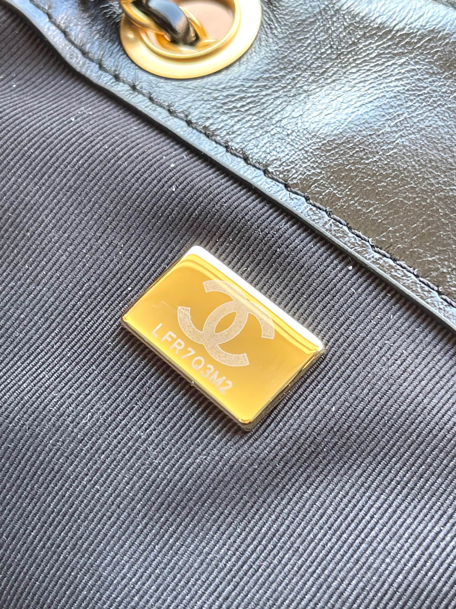 Chanel gold logo label patch on black quilted leather bag