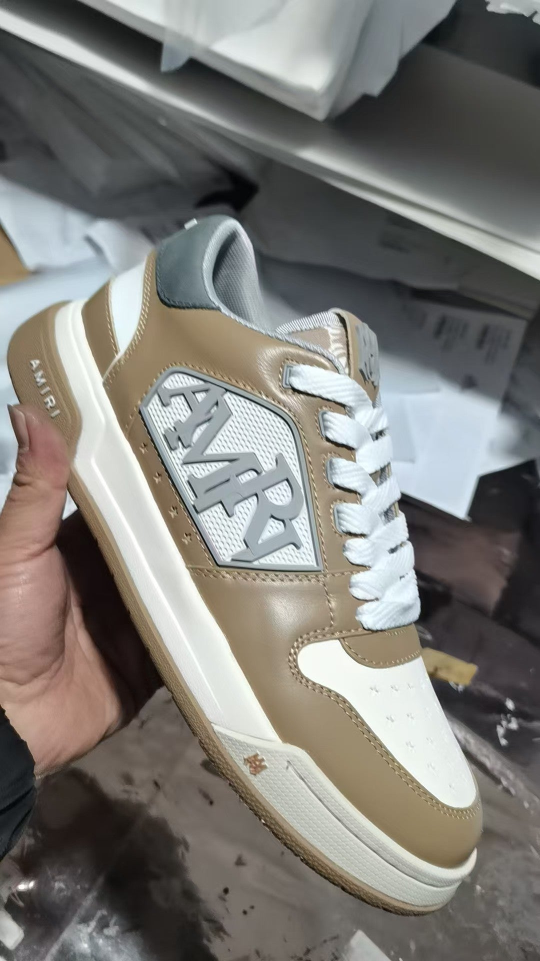 Tan and white sneakers with white laces, side logo patch, and low profile sole