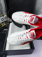 Low-top sneakers with red patterned tongue lining and white lace-up upper