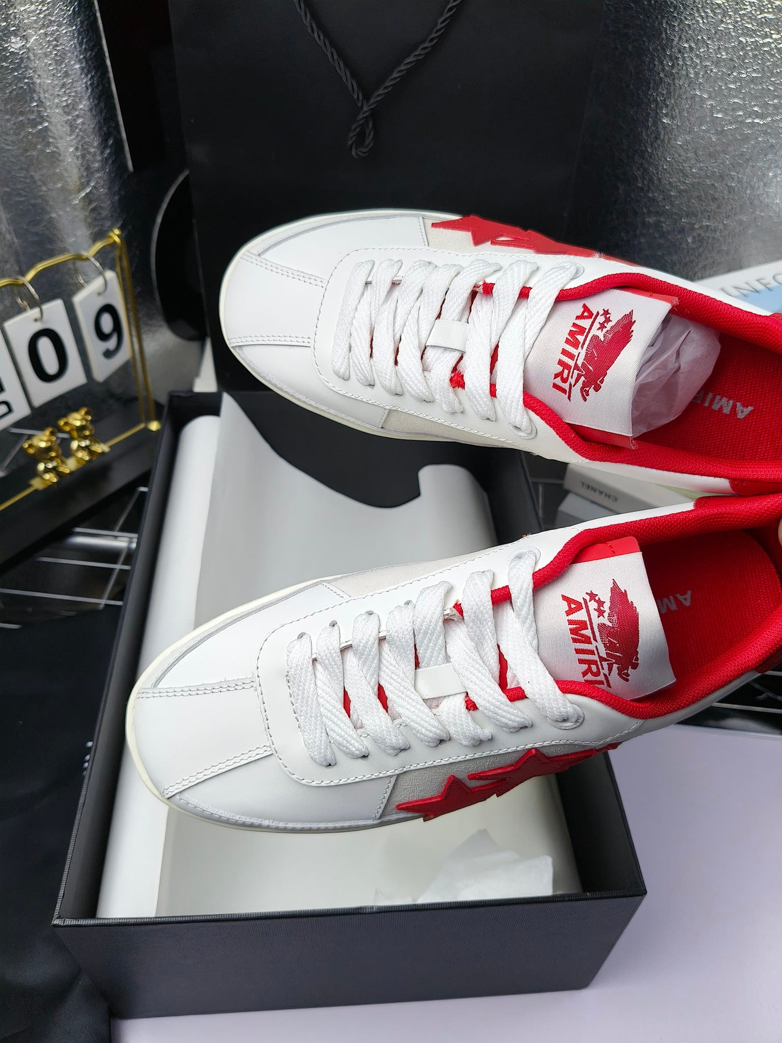 Low-top sneakers with red patterned tongue lining and white lace-up upper