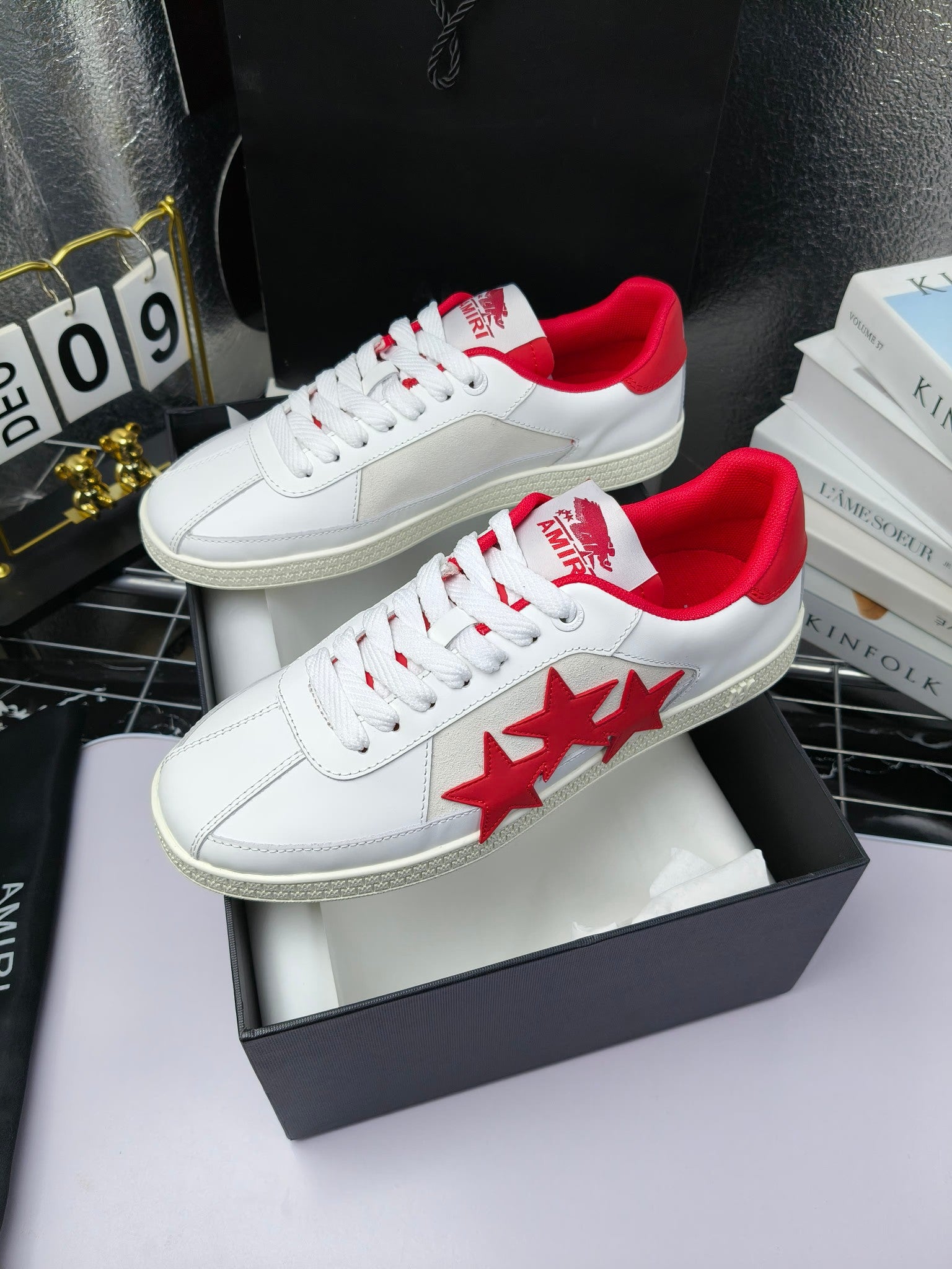 Pair of white low-top sneakers with red star logo on side and red heel collar